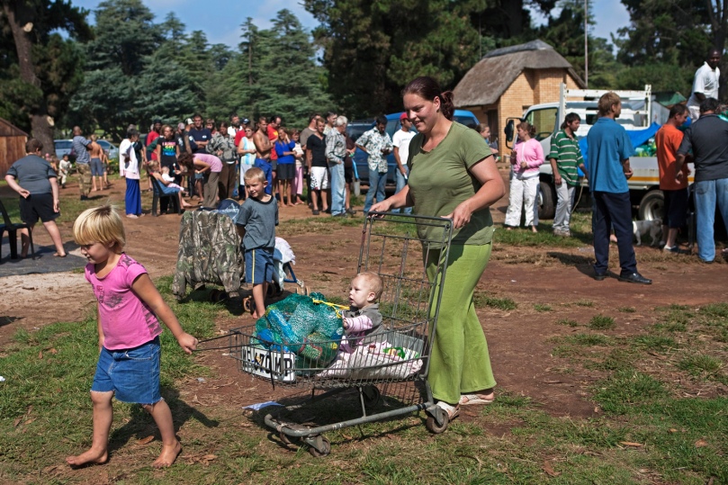 A woman pushes a cart with a monthly supply of food aid donated to residents of a squatter camp for poor white South Africans at Coronation Park in Krugersdorp, March 6, 2010. A shift in racial hiring practices and the recent global economic crisis means many white South Africans have fallen on hard times. Researchers now estimate some 450,000 whites, of a total white population of 4.5 million, live below the poverty line and 100,000 are struggling just to survive in places such as Coronation Park, a former caravan camp currently home to more than 400 white squatters. Picture taken March 6, 2010. To match feature SAFRICA-WHITES/ REUTERS/Finbarr O'Reilly (SOUTH AFRICA - Tags: SOCIETY BUSINESS) FRANCE MAGAZINES OUT. FOR MORE INFORMATION, PLEASE CONTACT YOUR LOCAL SALES REPRESENTATIVE.